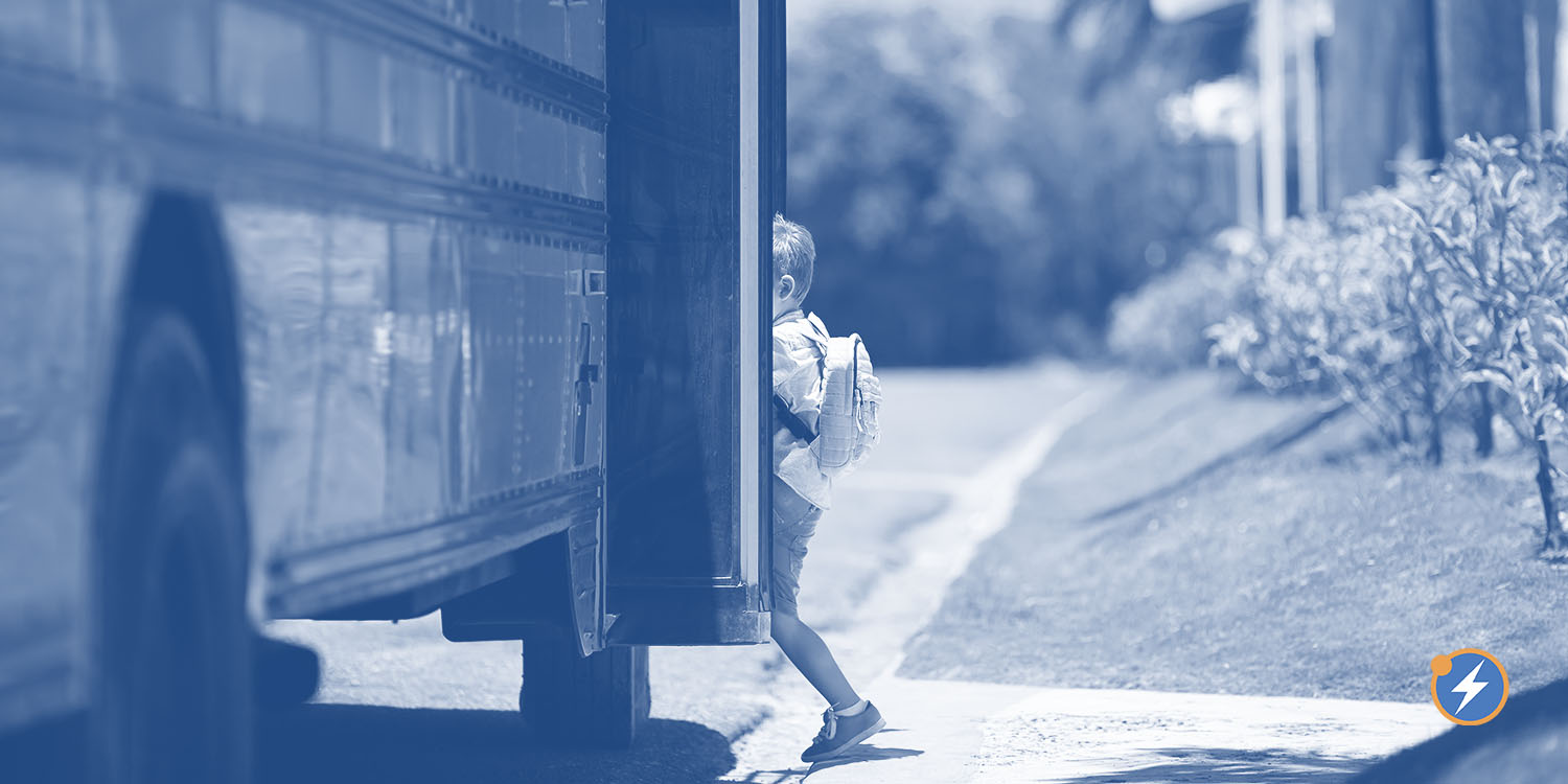 A schoolkid boards an electric school bus